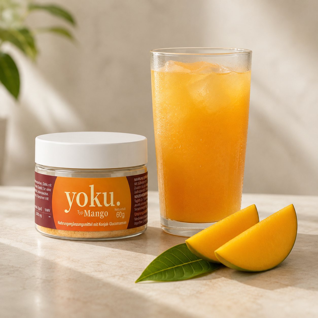 Yoku Mango neben einem Glas mit kaltem Mango-Drink