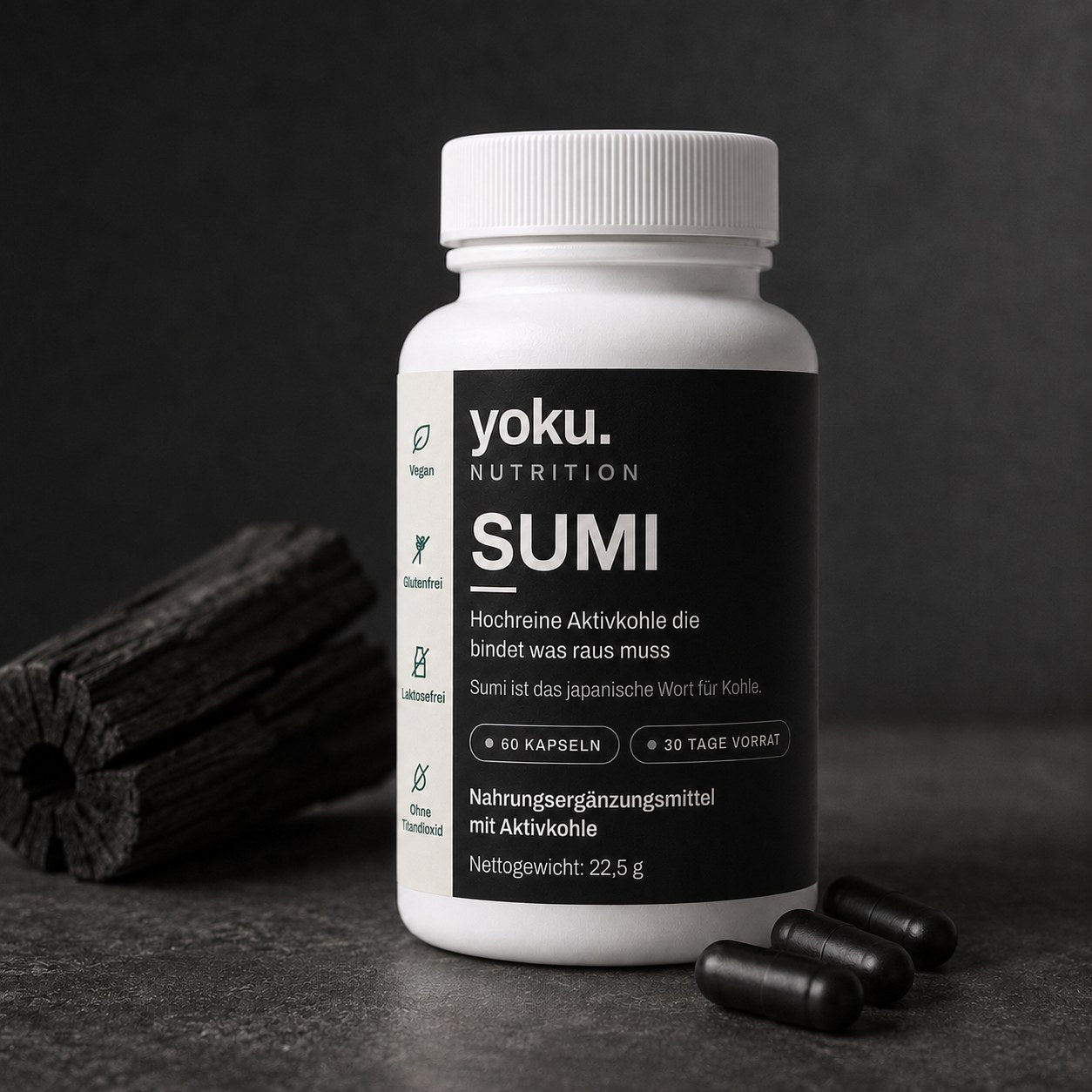 Yoku SUMI neben einem Stück Aktivkohle mit Kapseln